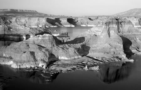Gray Scale Photo of Mountain Beside Body of Water in Bird's Eye View