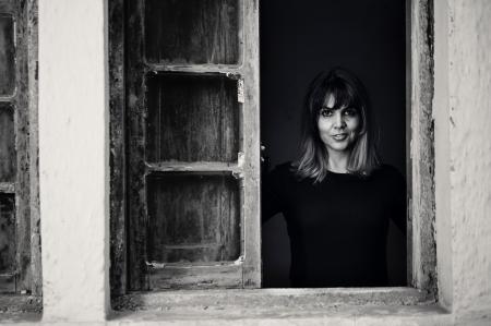 Gray Scale Photo of Woman in Window