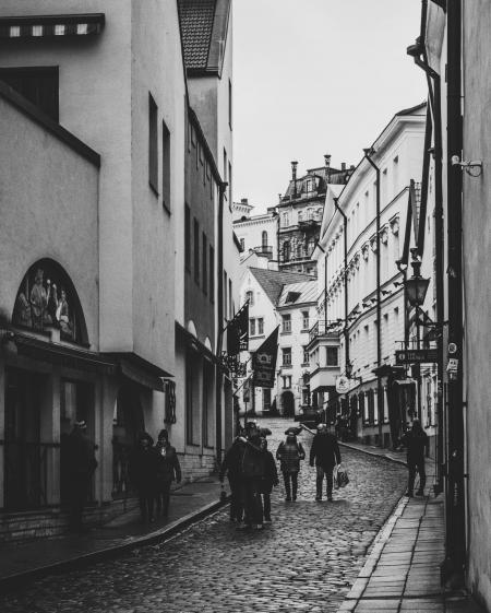 Grayscale Photo of Group of People Walking in Alley