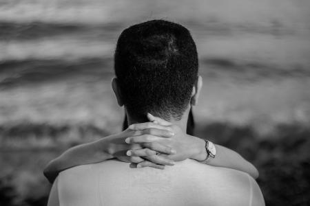 Grayscale Photo of Man Hugged by Woman