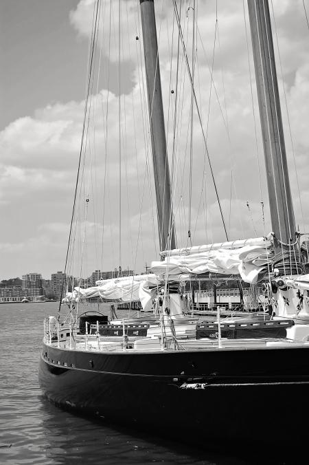 Grayscale Photo of Ship Near High-rise Mountains