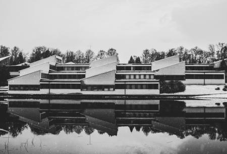 Grayscale Photo of White Painted House Near Body of the Water