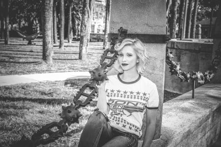 Grayscale Photo of Woman Sitting on Concrete Wall