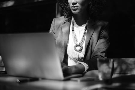 Grayscale Photo of Woman Using Her Laptop