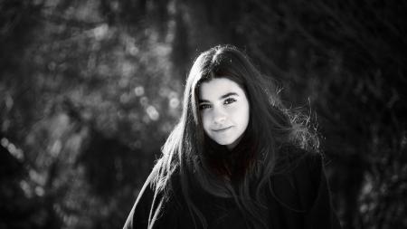 Grayscale Photo of Woman Wearing Coat Surrounded With Trees