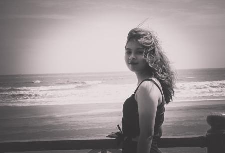 Grayscale Photo of Woman Wearing Tank Top Standing Near Seashore