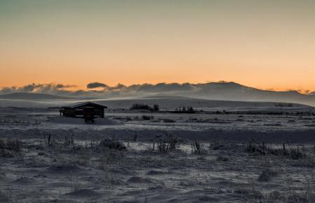 Grayscale Photo of Wooden Cabin in the Middle of Desert