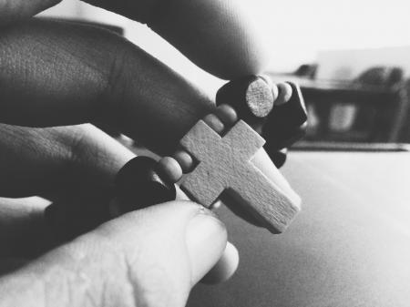 Grayscale Photography of Person Holding Rosary