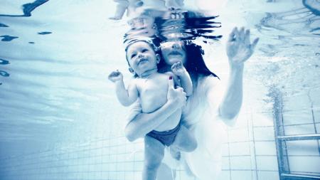 Grayscale Photography of Woman Holding Baby in Swimming Pool