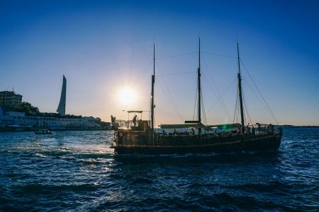 Green and Black Boat on Body of Water during Sunrise