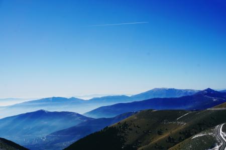 Green and Blue Fog Covered Mountains Under Blue Sky