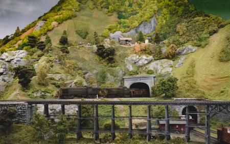 Green and Grey Mountains With Train Trail Going Inside