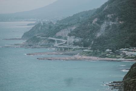 Green Island With Curved Bridge Near Body of Water