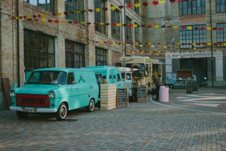 Green Minivan Near Brown Wooden Crate and Brown Food Truck