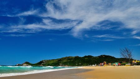 Green Mountain Near Sea Under White Clouds and Blue Sky