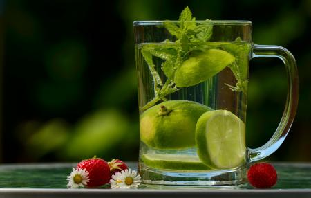 Green Round Fruit on Clear Glass Mug With Water