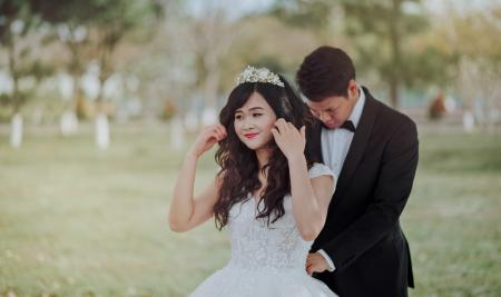 Groom Tying Bride's White Lace Wedding Gown at the Back