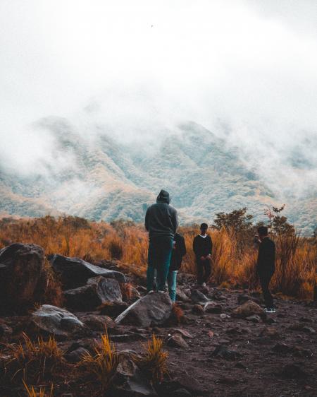 Group of People Near Foggy Mountain