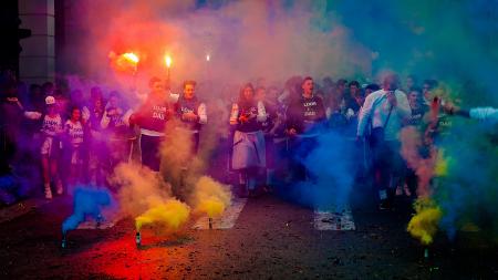 Group of People on Road With Assorted-color Smokes