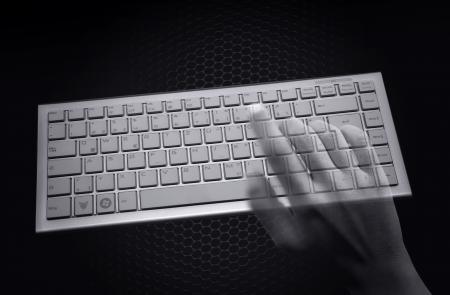 Hacking concept - Transparent hands over computer keyboard