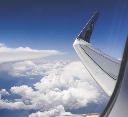 High-angle Photograph of Airplane Wings Above the Clouds Under Clear Blue Sky