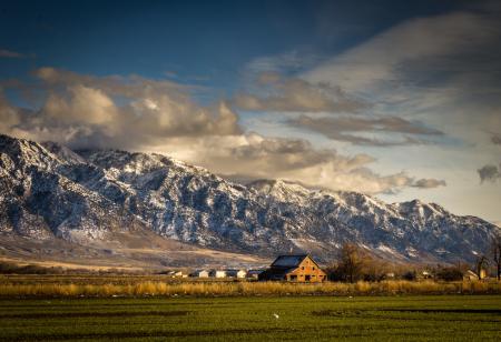 House Near Lawn Field and Mountain Cliff