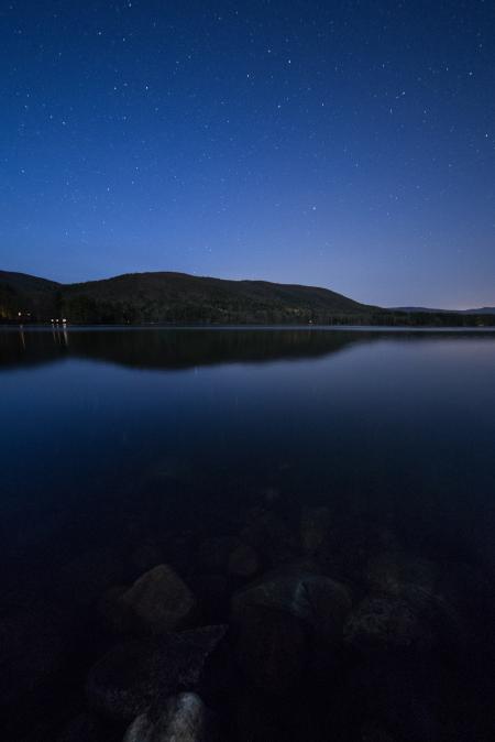 Lake View Under Clear Blue Night Sky during Night Time