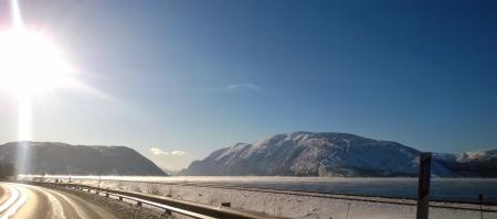 Landscape Photo of Gray Road Across Two Gray Land Formations