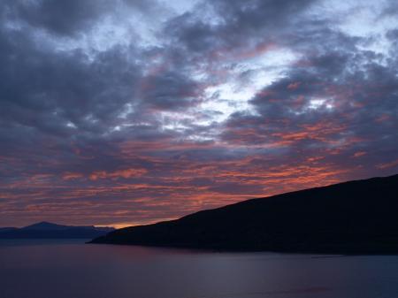 Landscape Photography of Black Rocky Formation With Orange Horizon Under Blue Clouds