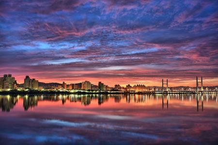 Landscape Photography of City Near Suspension Bridge Near Body of Water during Golden Hour