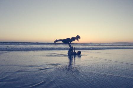 Landscape Photography of Man Lifting Woman by His Foot on Seashore