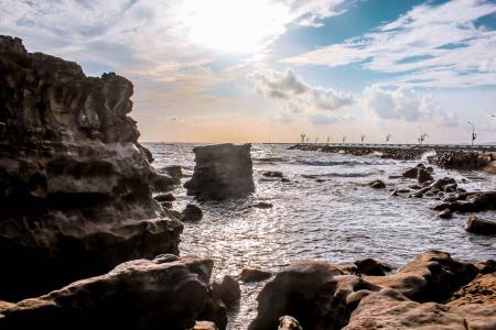 Landscape Photography of Rocks Surrounded by Body of Water