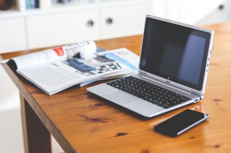 Laptop & cell phone on a wooden desk