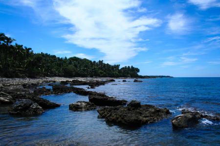 Large Rocks on Seashore Under White Cloudy Sky during Daytime