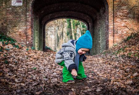 Little boy and autumn leaves