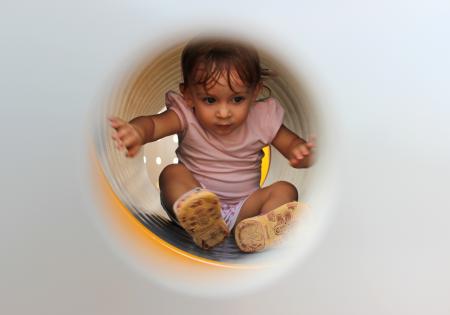 Little Child Playing Inside Tube Playground