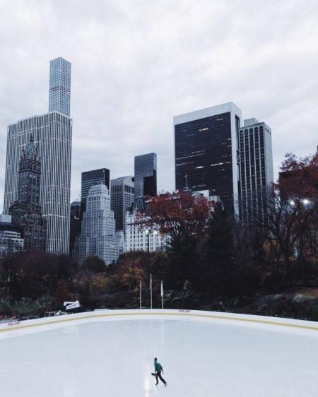 Lone Person Ice Skating Under Heavy Clouds