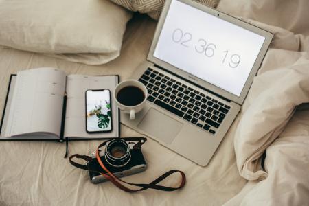 Macbook Air Beside Notebook and Camera