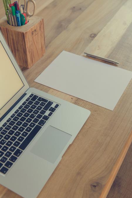 Macbook Air Beside White Paper and Click Pen on Top of Table