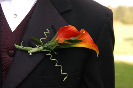 Macro Photography Of Black Formal Dress Coat With Red Flower Design