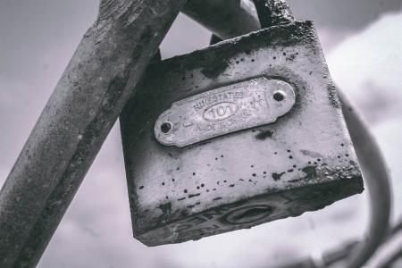 Macro Photography of Gray Metal Padlock on Gray Metal Bar