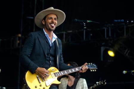 Main in Black Suit Jacket Playing Les Paul Electric Guitar