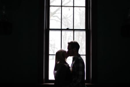 Man and Woman Kissing Beside Window