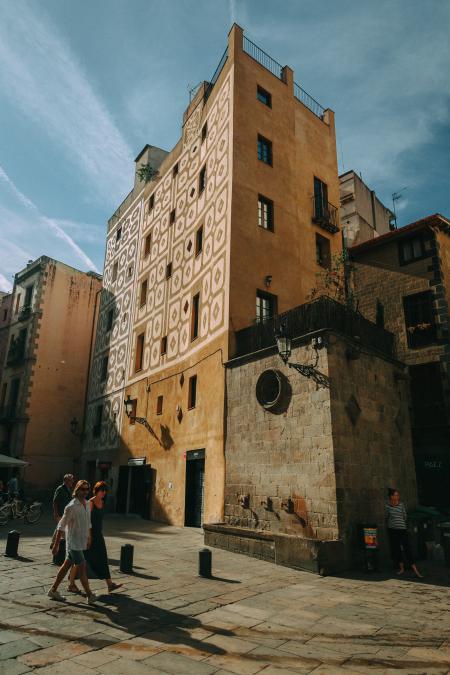 Man and Woman Walking Near Brown Concrete Building