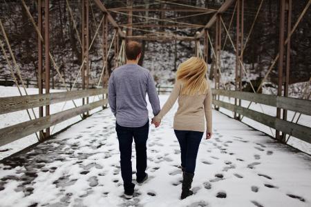 Man and Woman Walking on Snow Covered Road