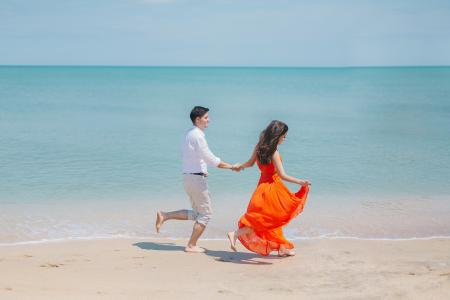 Man and Woman Walks Beside Green Sea