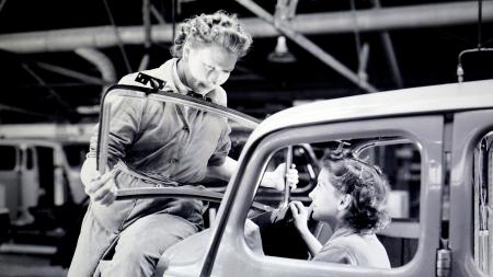 Man Carrying Car Windshield With Woman Inside a Car