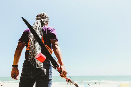 Man Holding Bow in Seashore