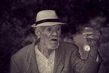 Man Holding Pocket Watch in Grayscale