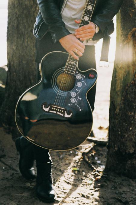 Man Holding Single Cutaway Acoustic Guitar